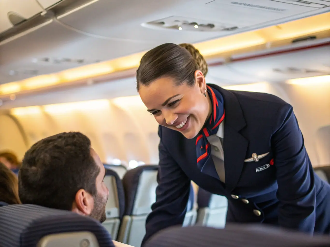 A photo showcasing a flight attendant interacting positively with a passenger, offering assistance and creating a comfortable environment.